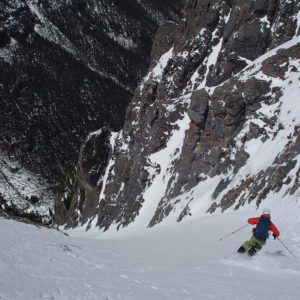 Skier skiing down couloir